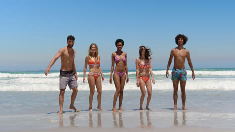 amigos jóvenes saltando juntos en la playa 4k