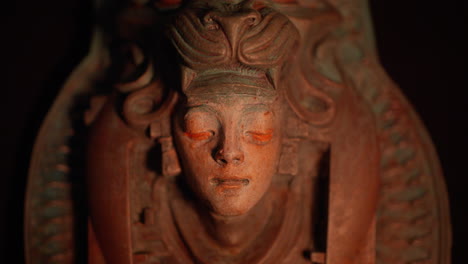 sculpture of a girl with beast trophy covered her head illuminated by flames