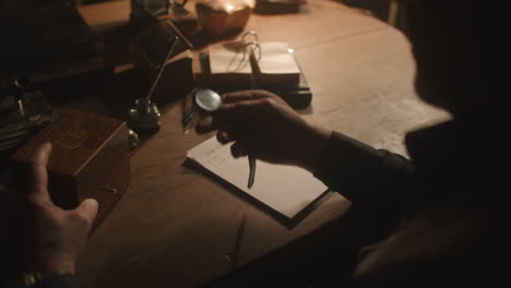 older passionate man evaluates an old watch in his office at night