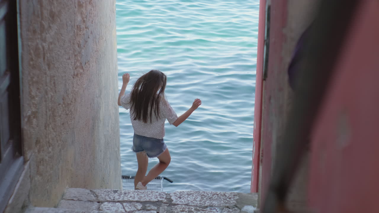 mujer caminando por las escaleras junto al mar