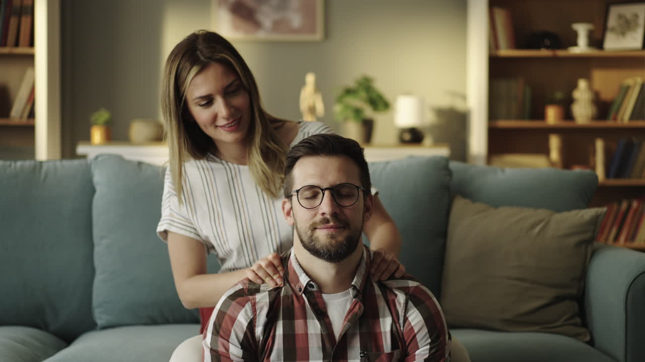 Donna che fa un massaggio alle spalle al suo partner a casa