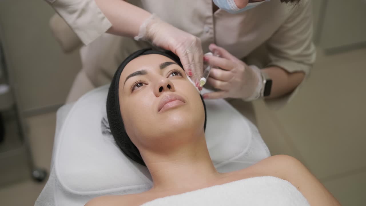um paciente sereno a receber terapia facial com toxina botulínica, com foco na precisão e cuidado num ambiente clínico