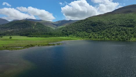elevándose por encima del lago azul hacia las laderas boscosas y las montañas