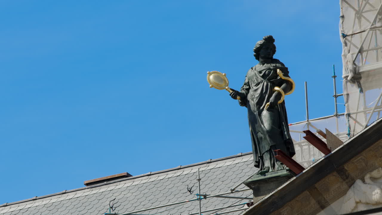 A statue on the Royal Palace in Amsterdam with a clear blue sky on a sunny day