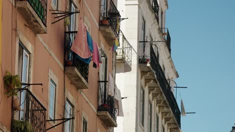 clothes hanging from balcony of traditional homes in lisbon portugal. low angle shot