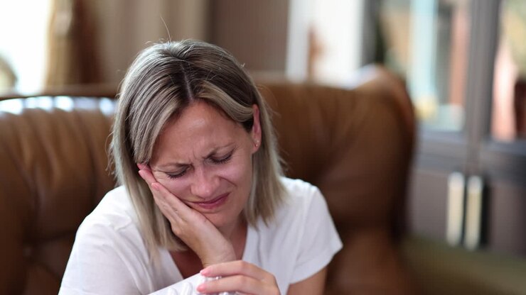 Woman with toothache holding pills