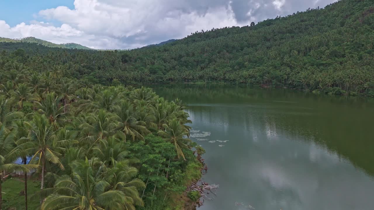 un dron aéreo disparado sobre el lago mahucdam, con colinas cubiertas de selva tropical que rodean el agua