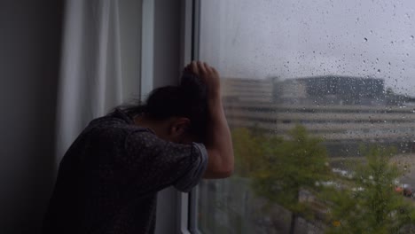 비오는 창 앞에서 절망에 빠진 청년, 모든 것을 잃었고 그의 삶에는 희망이 남아 있지 않습니다.