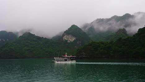 Handaufnahme-Eines-Touristenschiffs,-Das-Mit-Nebel-Am-Neuseeländischen-Berghang-Segelt