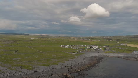 drone shot showing the continent and grass and campground near the atlantic ocean above the port of doolin by the wild atlantic way in doolin, co