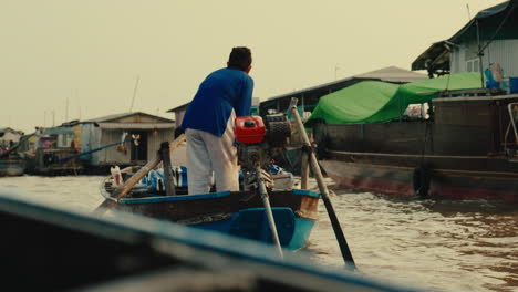 man rowing a boat in a floating market
