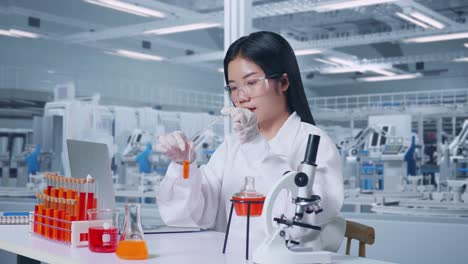 side view of asian woman scientist carrying out experiment and saying wow after looking at laptop in lab