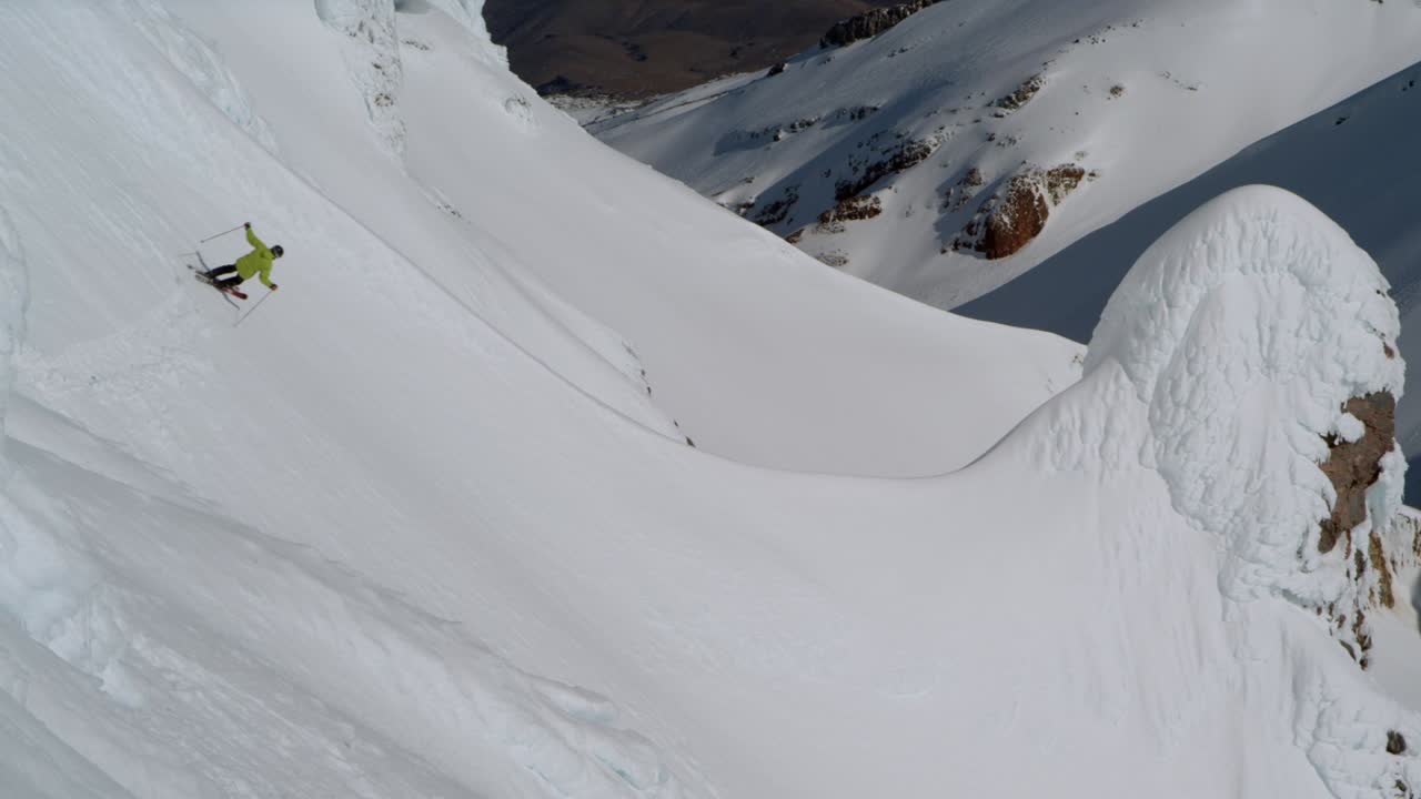 esquiador freeride tallado fuera de pista se convierte en una empinada ladera de montaña blanca, cámara lenta
