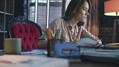 focused business woman writing finance report in home office