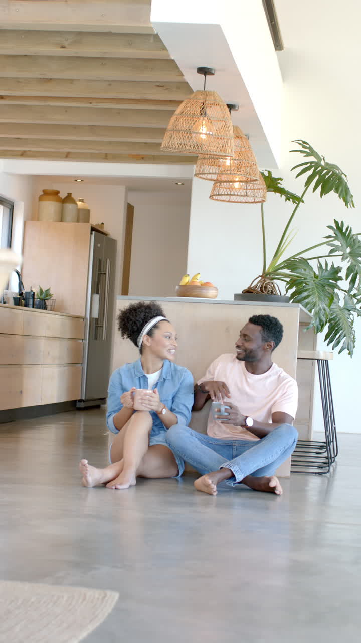 Vertical video: Relaxing at home, couple sitting on floor and enjoying coffee together