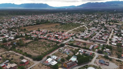 Aerial-establishing-shot-of-the-cafayate-town-of-salta-in-Argentina-with-Andean-Cordillera-Mountain-Range-in-Background