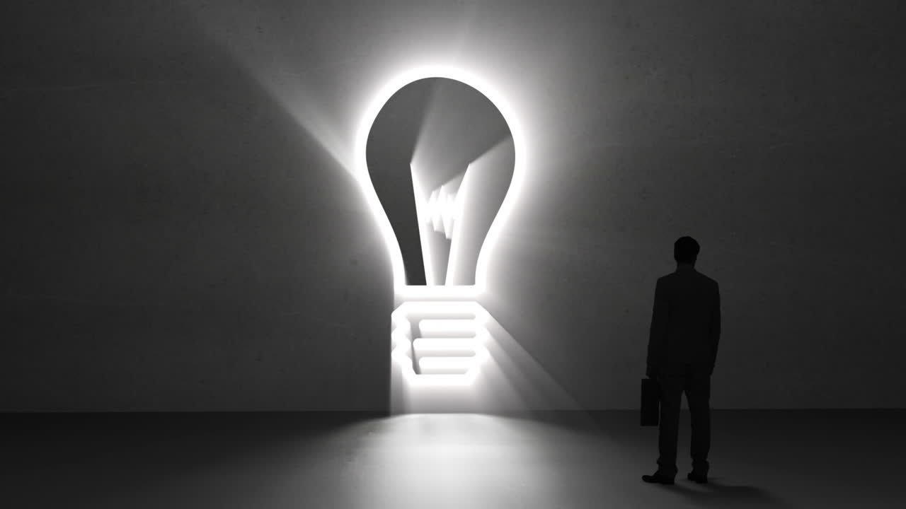 un hombre de negocios mirando una bombilla gigante.