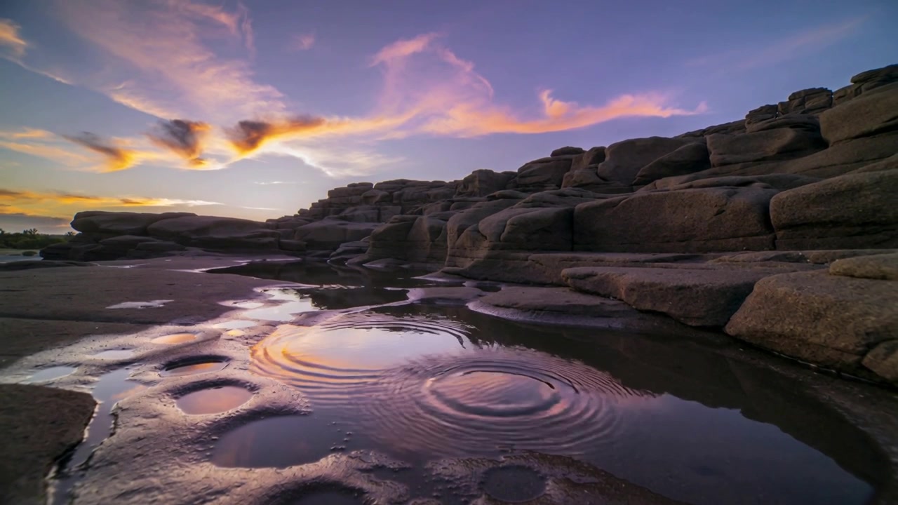 Rippling tidal pools making rings on coast while light breeze stirring surface, potholes, cliff
