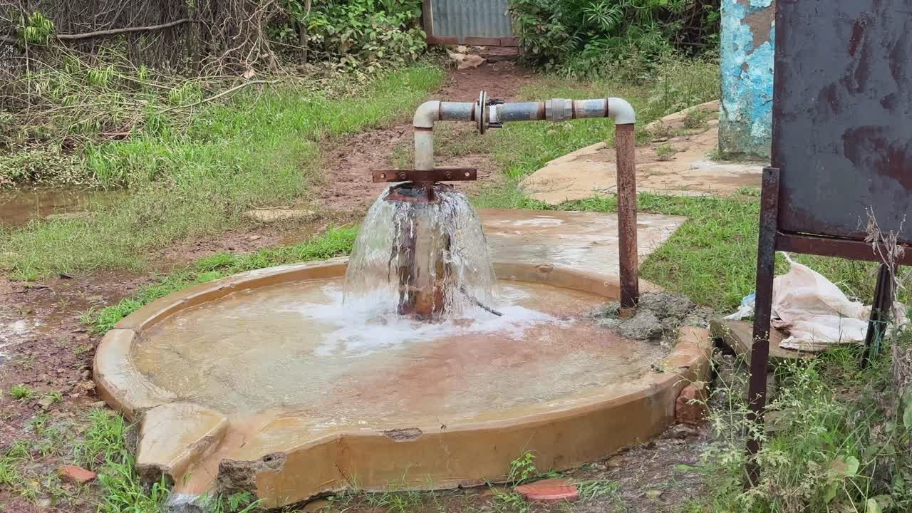 wide shot of groundwater rising to the surface and flows out without the need for a pump