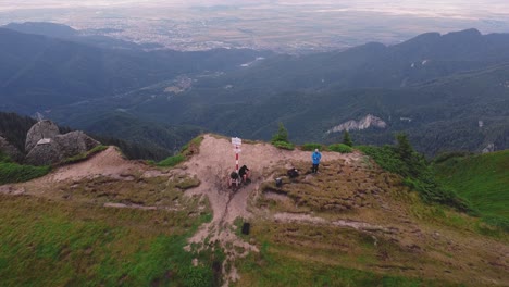 aerial drone shoot moving forward above a mountain peak and performing a dive over a ridge and down into a valley