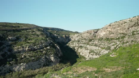 aerial: flying in canyon near magrr ix-xini bay on gozo island in malta