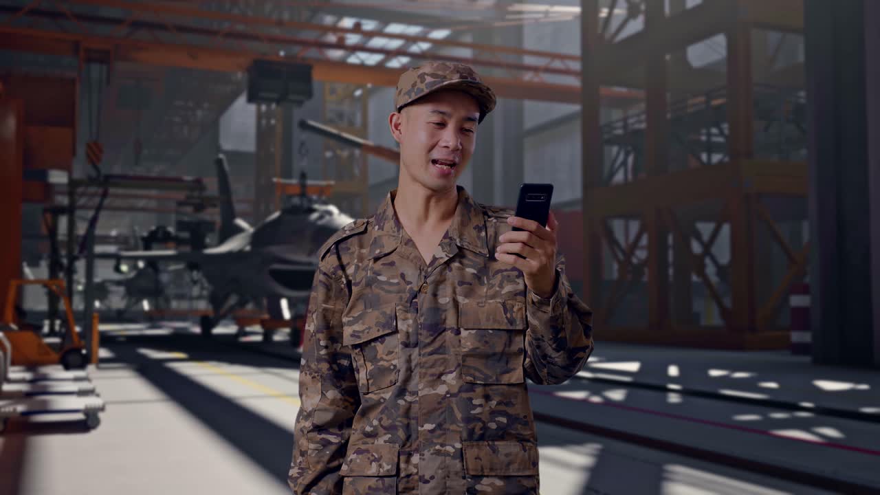 Soldato sorridente in uniforme mimetica che saluta e parla durante una videochiamata