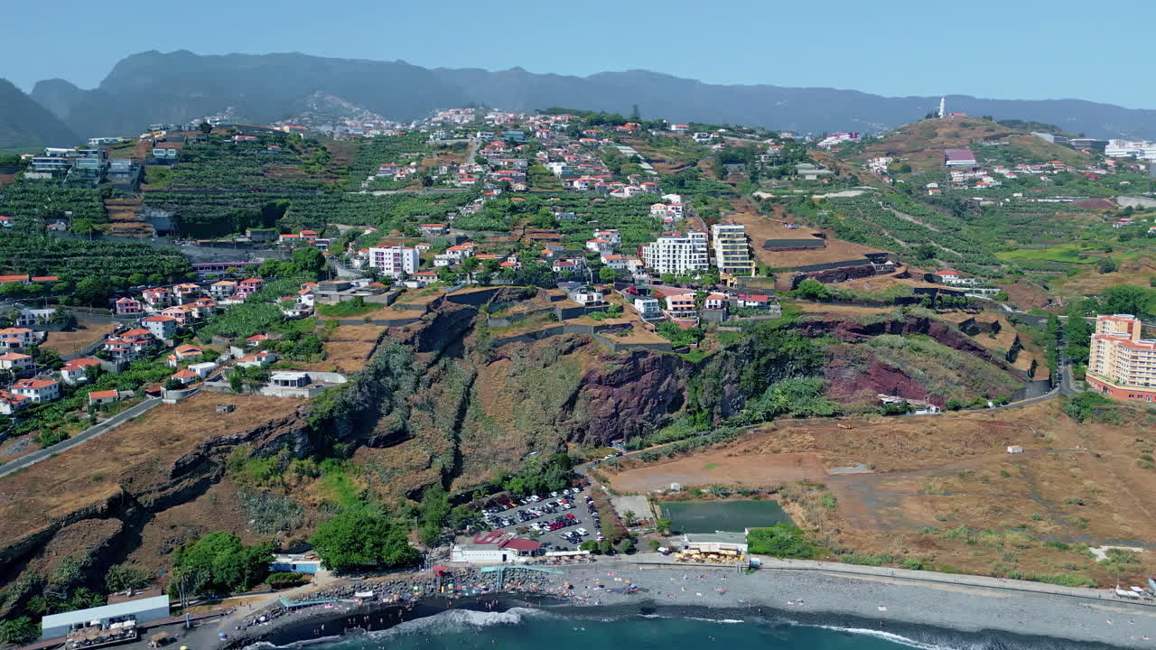 Zona residenziale sulla costa con vista aerea di case con tetti di tegole su pendii scoscesi