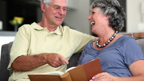 mature couple laughing while looking at a book