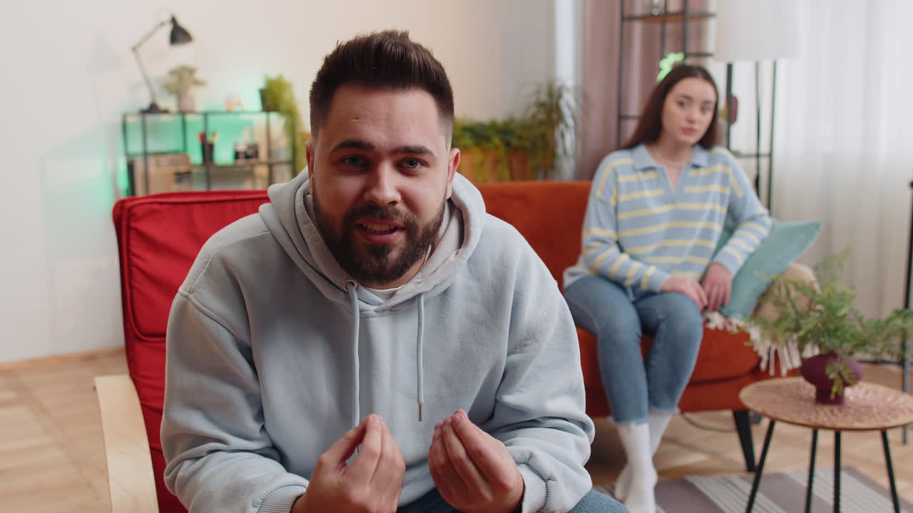 Aggressive man talking to camera about quarreling with woman at home conflict at family couple