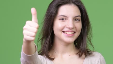 young happy beautiful woman smiling while giving thumbs up
