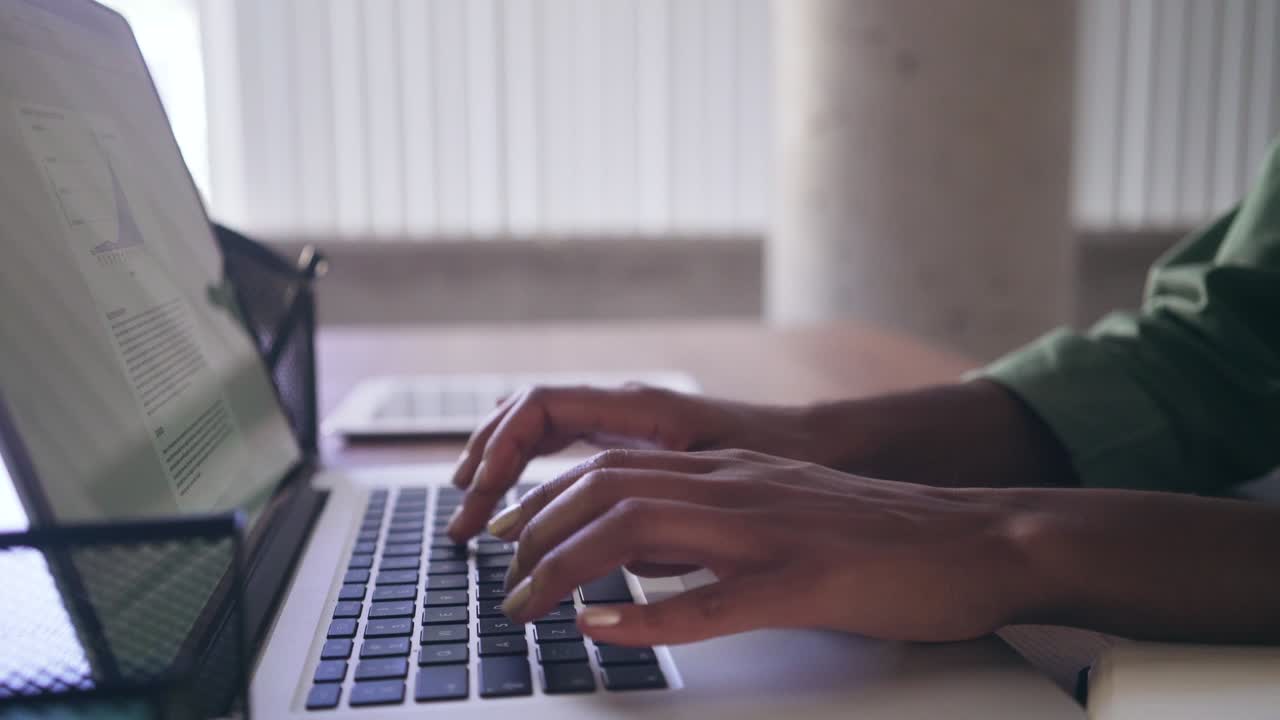 Businesswoman typing on laptop after writing on her personal organizer