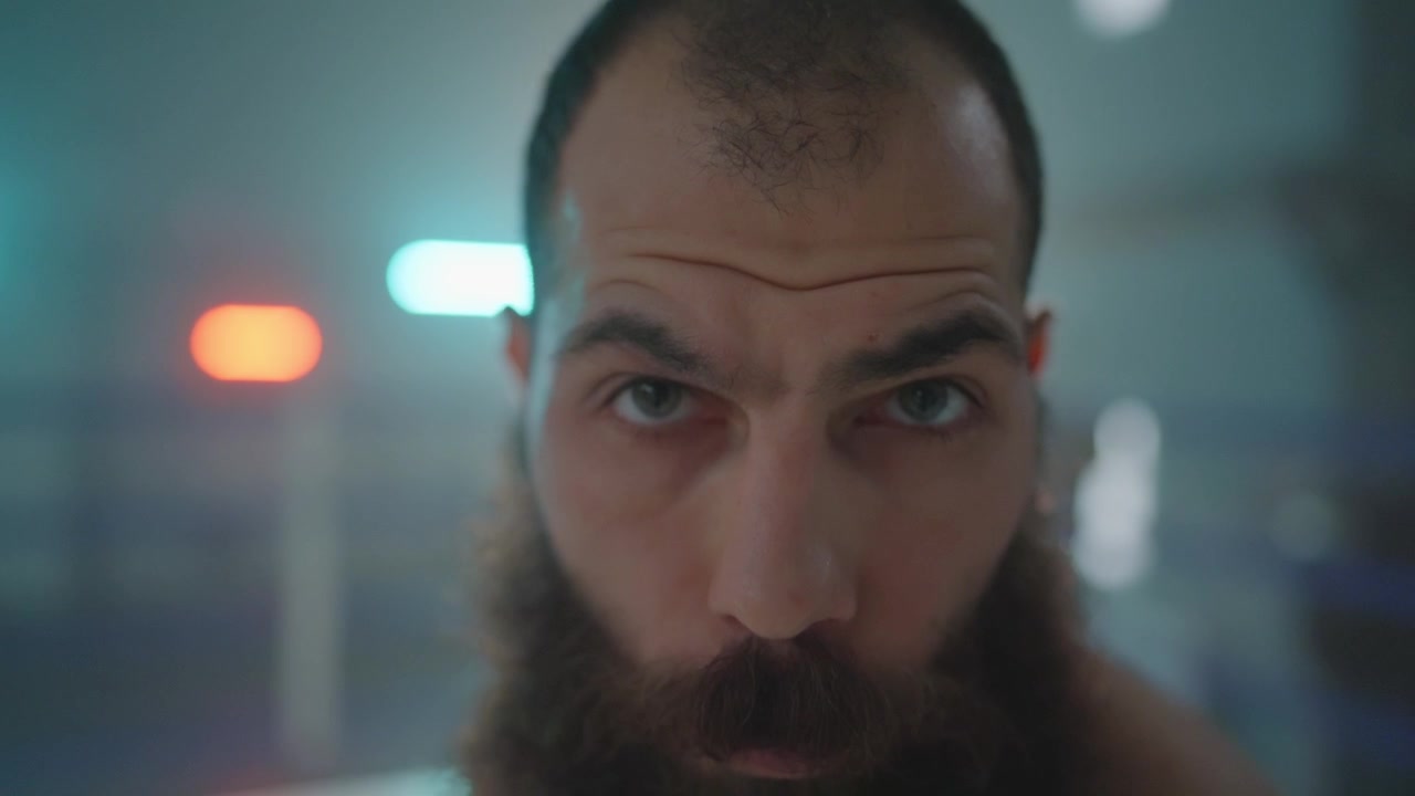 Close-Up Portrait of an Intense Bearded Man in a Boxing Ring