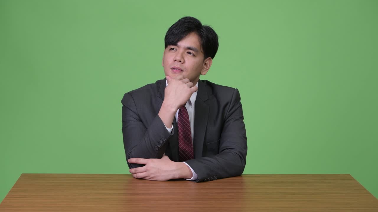 녹색 배경에 젊은 잘생긴 아시아 사업가