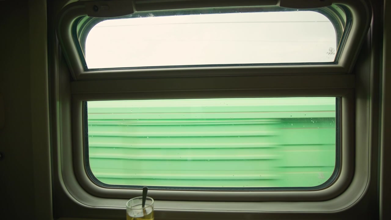 View from a Train Window of a Passing Freight Train