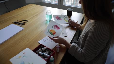 young girl painting watercolor drawings