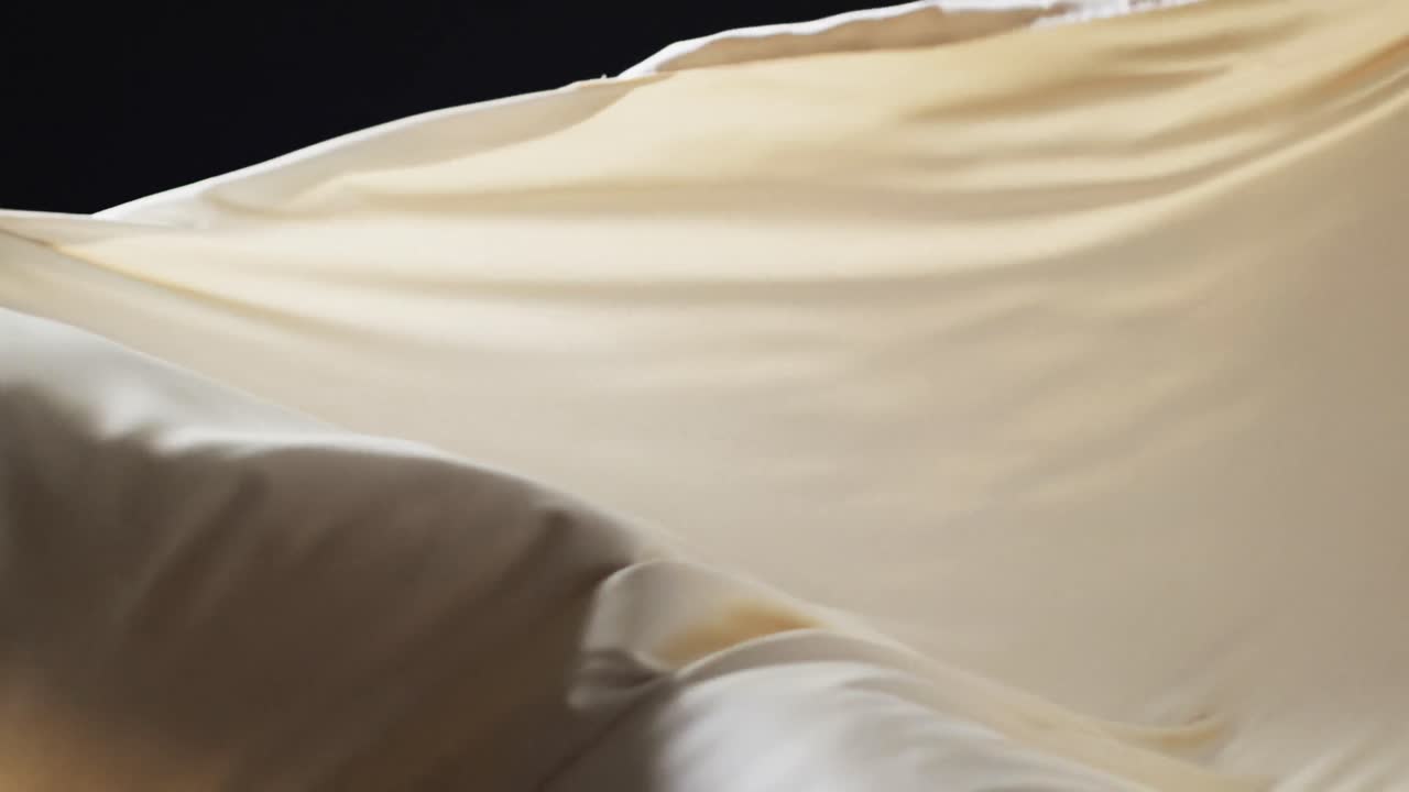 검은색 배경 위에 복사 공간과 함께 크림 천을 불어 넣는 애니메이션