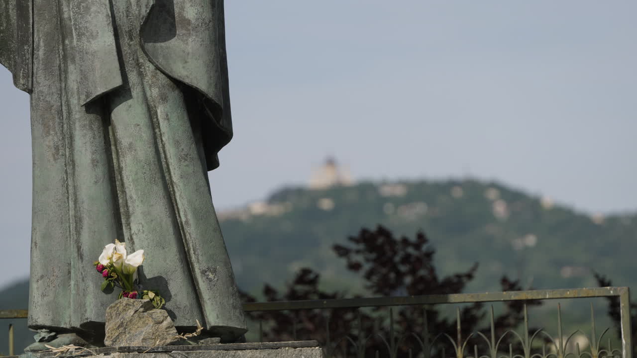 백그라운드에서 초점이 맞지 않는 바실리카 뒤 수페르가(basilica du superga)가 있는 조각상과 꽃의 정적인 샷
