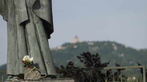 static shot of statue and flowers with basilica du superga out of focus in background