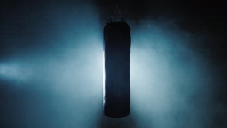 poire de boxe sous les projecteurs et dans le brouillard