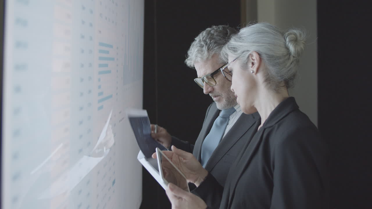 профессиональные инвесторы с документами и планшетом