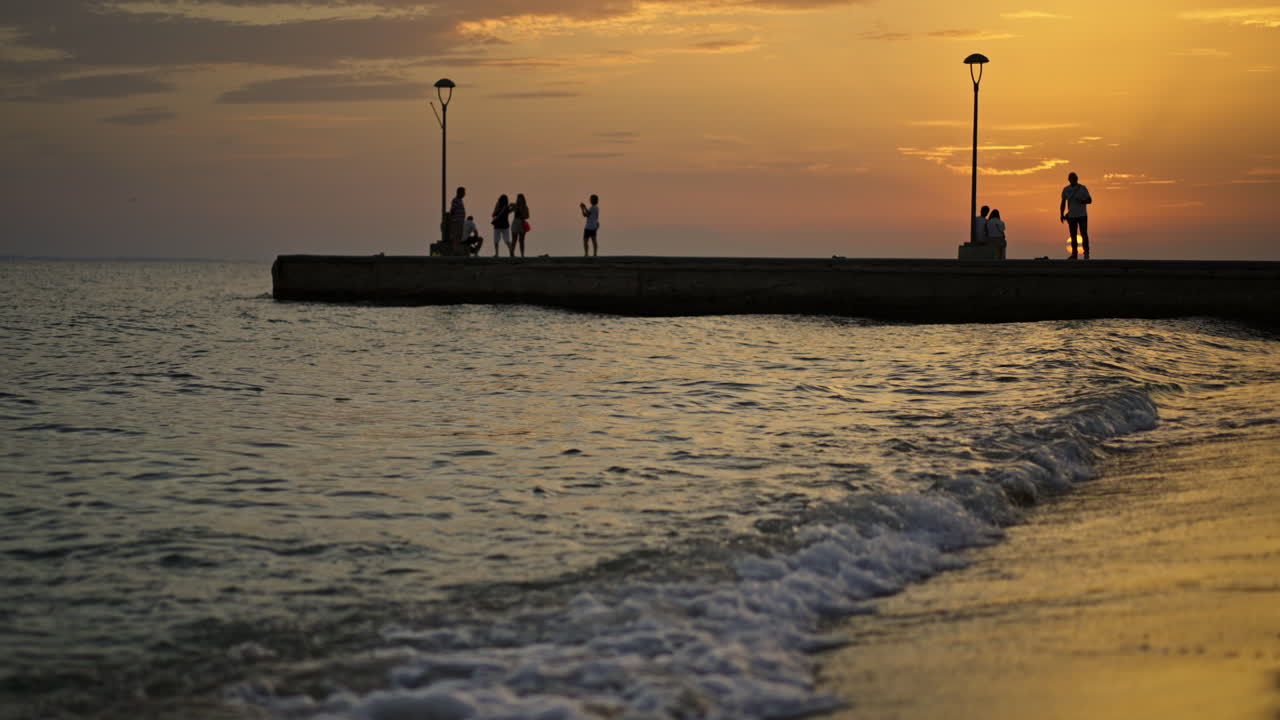 해변 에서 일몰 을 즐기는 사람 들