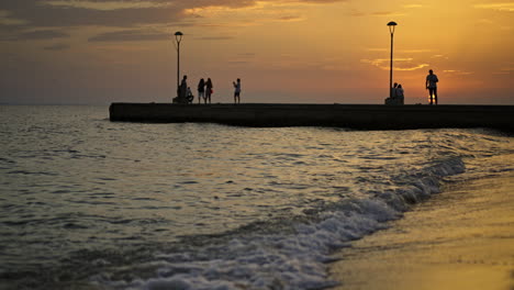 gente disfrutando de una puesta de sol en la playa