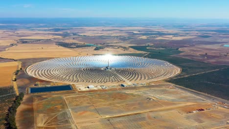 photovoltaic solar panels power plant. thermosolar power plant, a center of solar farm surrounded by fields - panorama view with a drone - environment concept