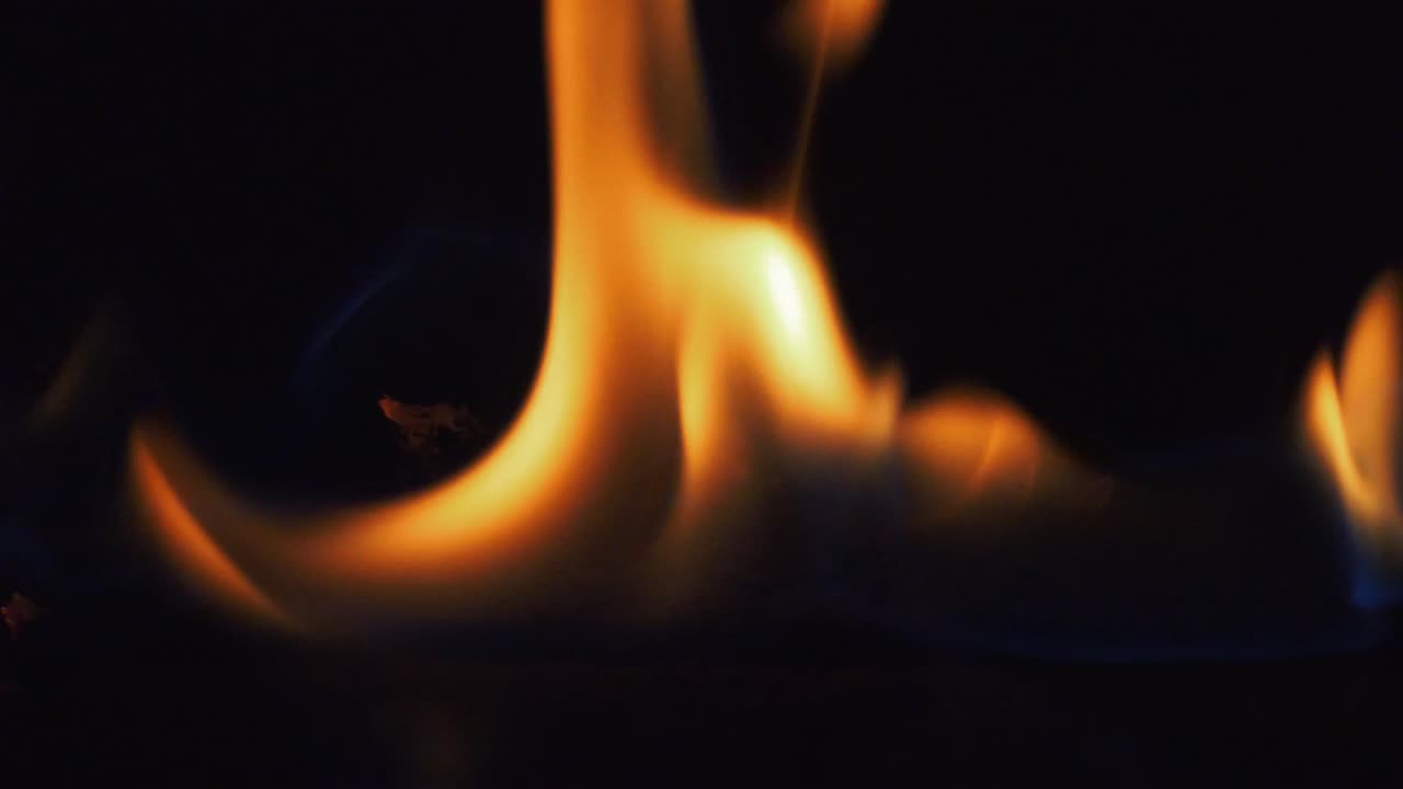 Close up of burning log in fireplace in slow motion