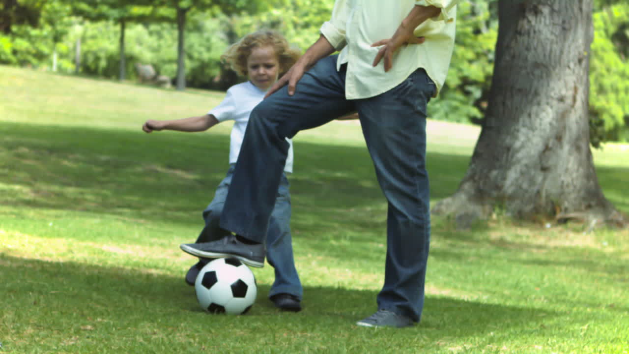 niño pateando la pelota en cámara lenta