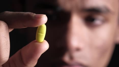 person holding a yellow pill