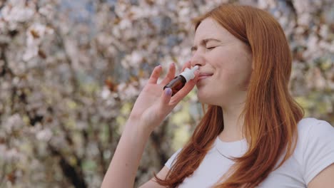 woman using nose spray outdoors