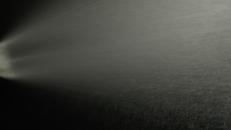young man applying perfume to skin in the dark, close up of spraying deodorant luxury perfume.
