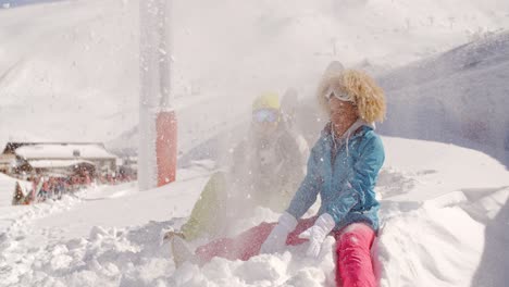 young couple playing in the snow at a ski resort