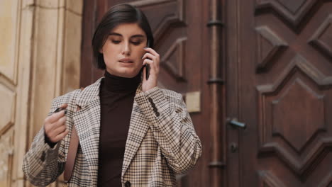 caucasian businesswoman using smartphone outdoor.